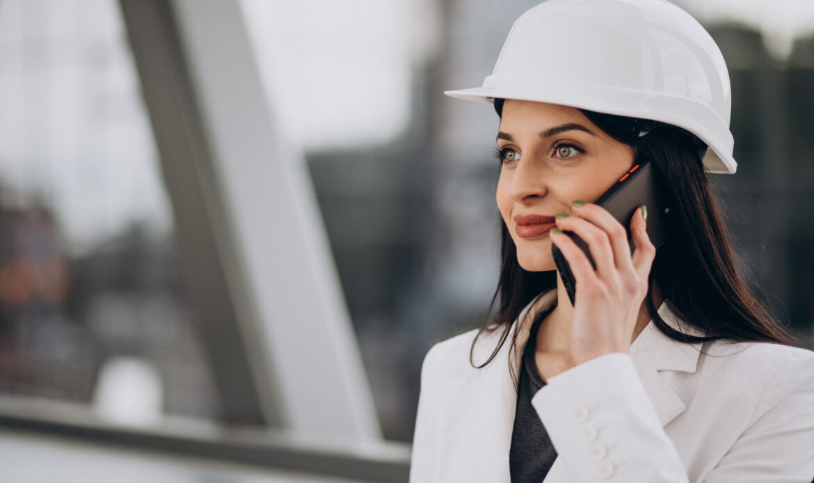Young business woman wearing hard hat at building object